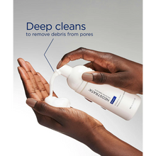 Load image into Gallery viewer, A lifestyle image of a person dispensing white foam from the NeoStrata Exfoliating Wash bottle into their palm. Dark blue text above states that the formula "Deep cleans to remove debris from pores."
