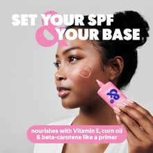 Load image into Gallery viewer, A woman applying Clear Sun Balm to her cheek, highlighting its use as a nourishing primer with Vitamin E.
