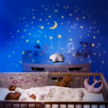 Load image into Gallery viewer, Lifestyle shot of a starry night light projection onto a nursery wall above a sleeping baby in a crib, showing the calming atmosphere created by the musical projector.
