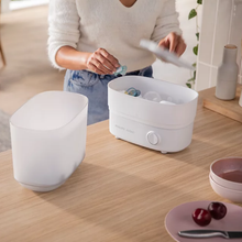 Load image into Gallery viewer, Parent placing soothers and feeding accessories into the Philips Avent steam steriliser
