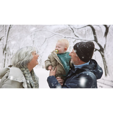 Load image into Gallery viewer, A child in a winter coat using a yellow monkey-themed Philips Avent Ultra Air Nighttime soother (SCF376/32) while being held by adults in the snow.
