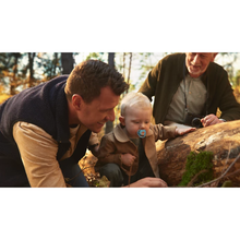 Load image into Gallery viewer, A toddler using a blue monkey-design Philips Avent Ultra Air soother during an outdoor family outing in the woods with his father and grandfather.
