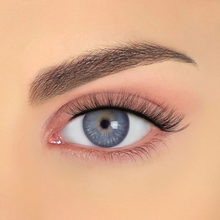 Load image into Gallery viewer, Closeup of MIA false eyelashes on blue eyes showcasing ultra-curly, lash extension effect.
