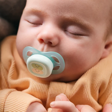 Load image into Gallery viewer, A baby sleeping peacefully while using a light green Philips Avent Ultra Air pacifier designed for maximum airflow and comfort.
