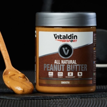 Load image into Gallery viewer, A jar of Vitaldin Sport All Natural Smooth Peanut Butter on a dark surface next to a wooden spoon filled with creamy peanut butter, highlighting its 26% protein and vegan features.
