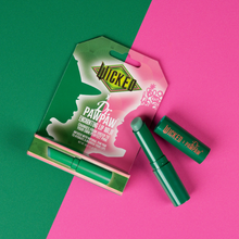 Load image into Gallery viewer, WICKED x Dr. PAWPAW Enchanting Lip Balm displayed open alongside its original packaging on a green and pink background, showcasing the colour-changing balm stick.

