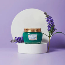 Load image into Gallery viewer, Yardley London English Lavender Brilliantine (80g) hair pomade lifestyle image, featuring the classic teal glass jar with a gold lid and fresh lavender sprigs for traditional hair grooming and shine.
