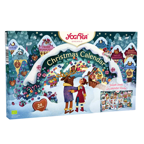 The boxed cover of the Yogi Tea 2025 Christmas Advent Calendar, featuring a colorful winter scene with two figures and reindeer in front of a snowy gingerbread-style village.